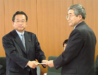 企業会計審議会で，日本版SOX 法対応の「基準」および「実施基準」の文書を手渡す安藤英義会長（右）と，これを受け取る山本有二 内閣府特命担当大臣（金融・再チャレンジ担当）（2007年2月当時）