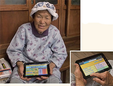 写真1●農産物の販売会社いろどりが配布したタブレット端末とそれを利用する農家の女性