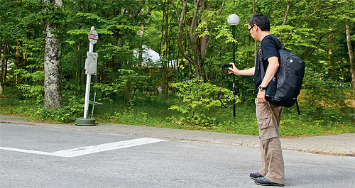 軽井沢にある「ホテルブレストンコート」のバス停前で写真を撮る星野社長