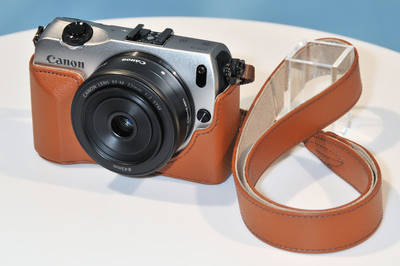 キヤノンが発表したミラーレス一眼「EOS M」。20～30代の“カメラ女子”をターゲットにしており、女性好みのカメラケースなどのアクセサリーが充実している。